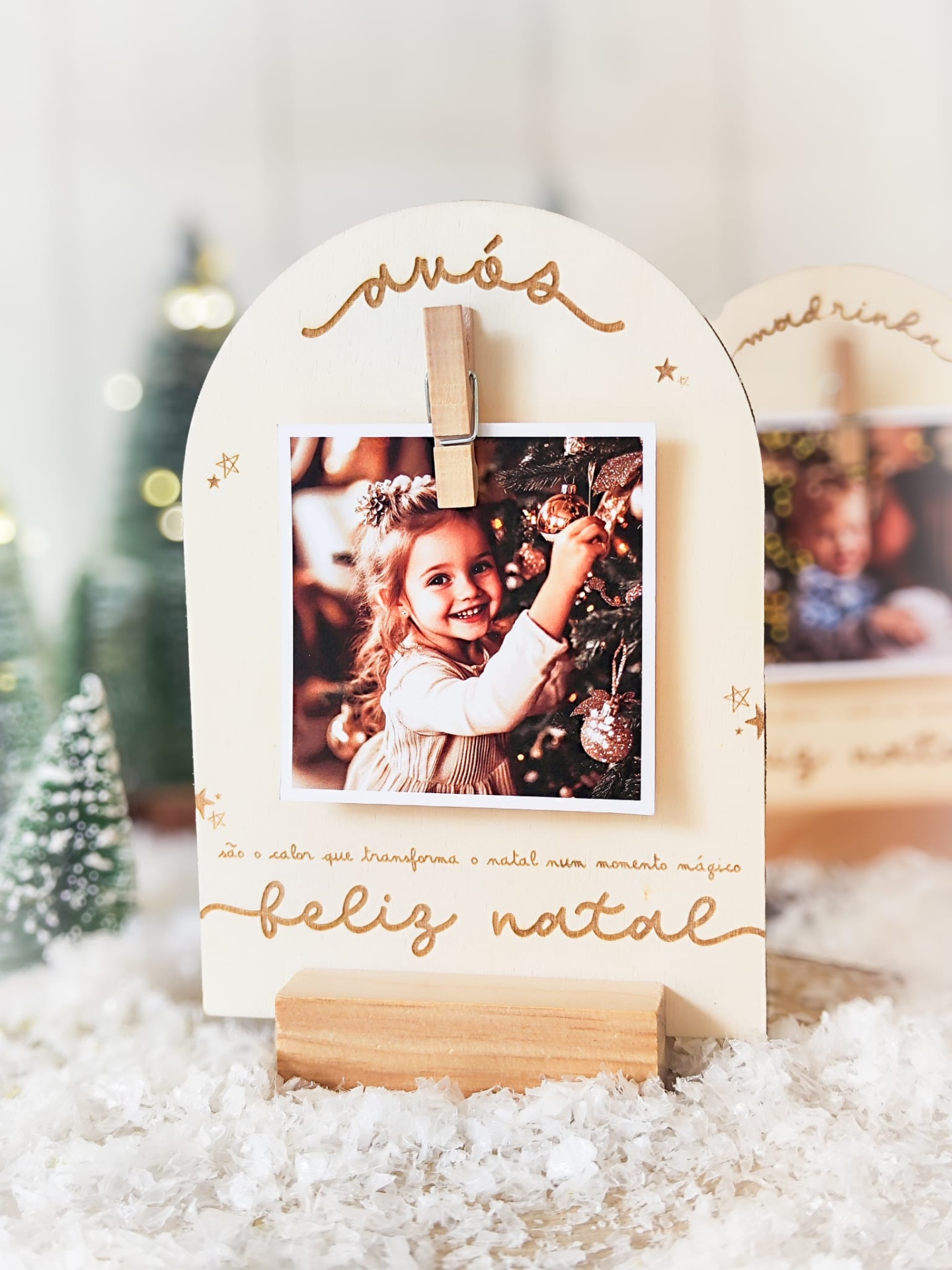 Suporte de madeira para foto de Natal com texto em português e decoração natalícia.