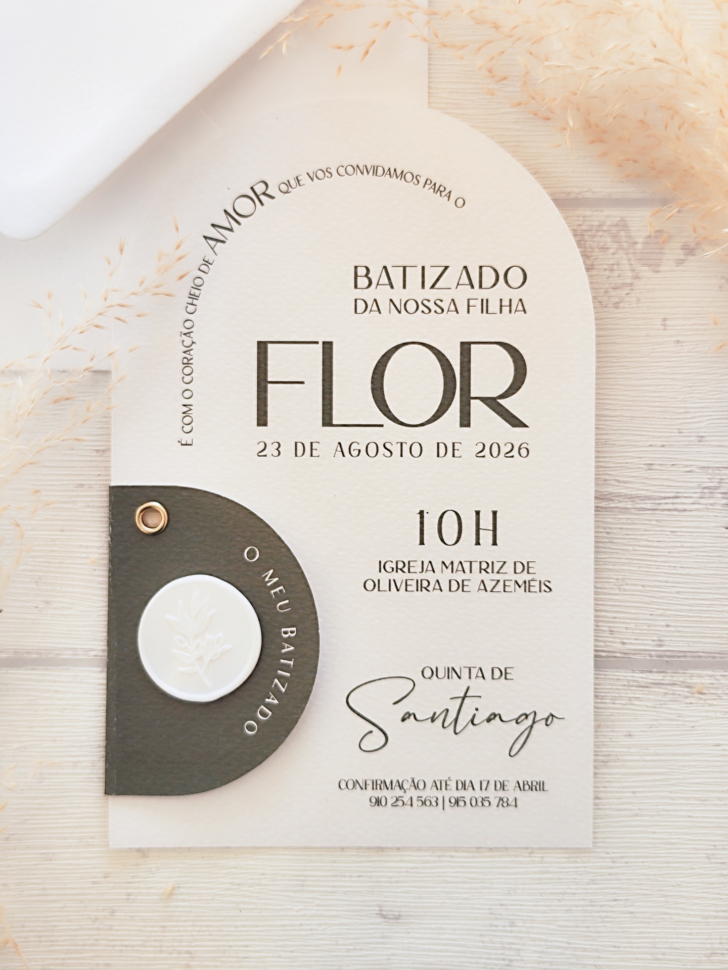 Convite de batizado da filha Flor, papel bege texturizado com detalhe em couro castanho escuro e selo branco, texto em preto.