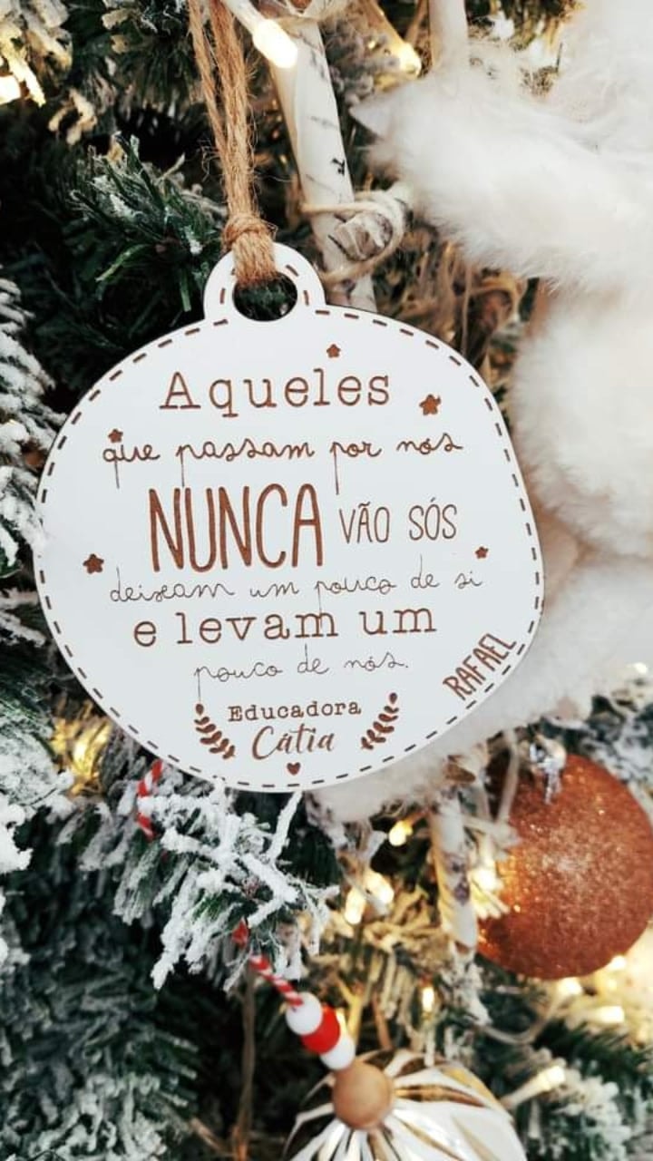 Ornamento de árvore de Natal branco com texto em português pendurado numa árvore de Natal