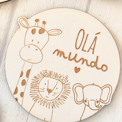 Prato redondo em madeira com desenho de girafa, leão, elefante e texto OLÁ mundo