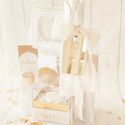 Kit de presente transparente com frasco, caixa e rótulos Madrinha decorados com tulipa e laço branco.
