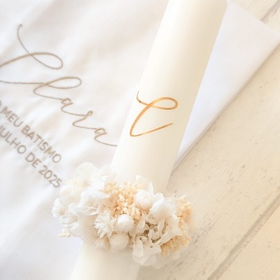 Vela branca alta decorada com flores e toalha bordada