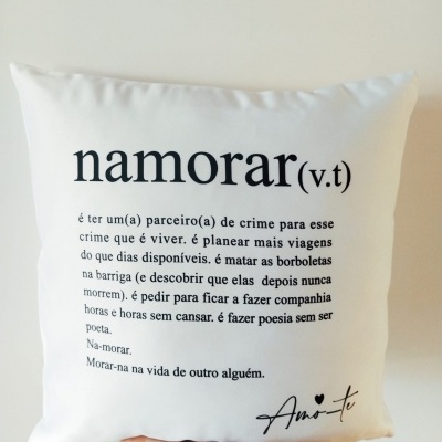 Almofada branca com texto preto e mão segurando