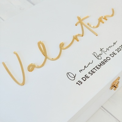 Caixa branca decorativa para batismo com nome e data em relevo dourado e texto preto.