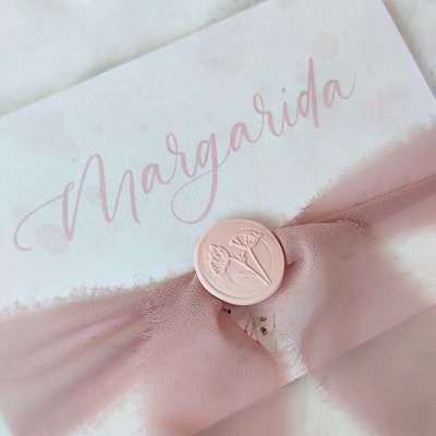 Envelope branco com nome Margarida, fita rosa e selo de cera com flores