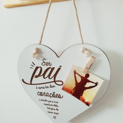 Placa em forma de coração com texto sobre paternidade e fotografia presa por mini pregador