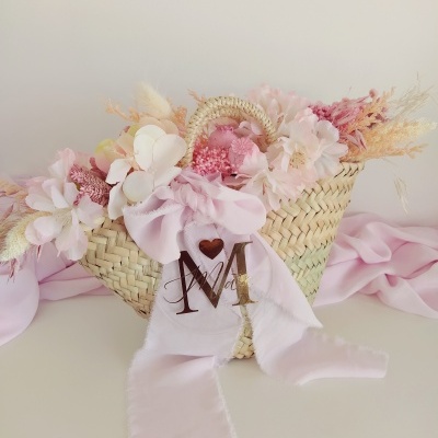 Cesta de palha com flores artificiais rosa e fita decorativa rosa com letra M