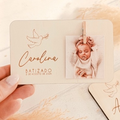 Cartão de batizado de madeira com nome Carolina, data, pomba gravada e foto de bebé com prendedor de madeira