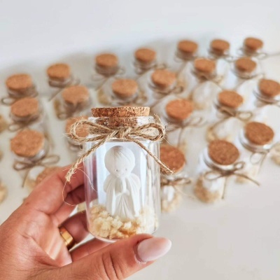 Frascos de vidro com figuras de anjos e tampas de cortiça.