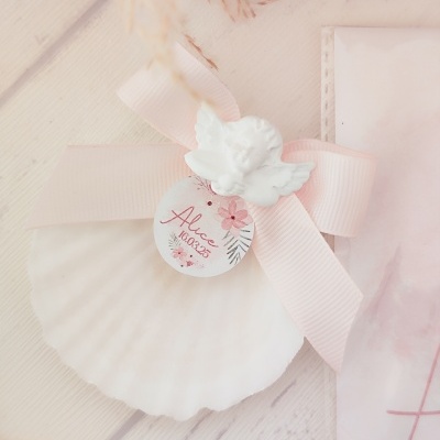 Concha branca com laço rosa, anjo e etiqueta com texto Alice 10.07.23