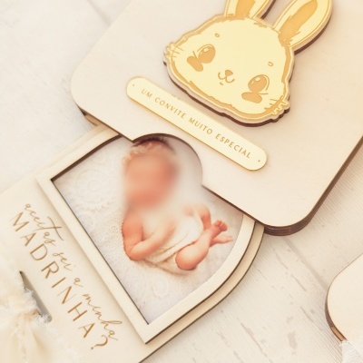 Convite de madeira com coelho amarelo, foto de bebé e texto em português