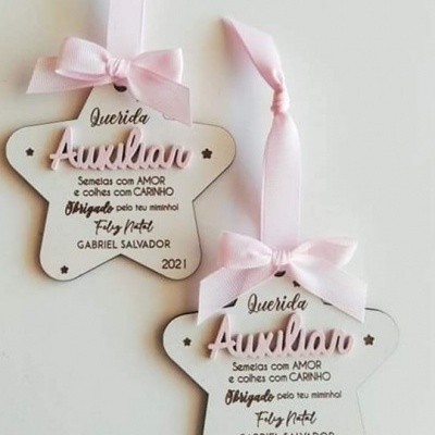 Enfeites estrela brancos com fita rosa e texto de agradecimento em português.