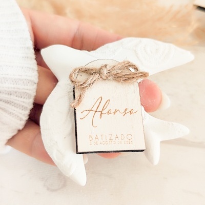 Anjo decorativo branco com etiqueta de batizado amarrada