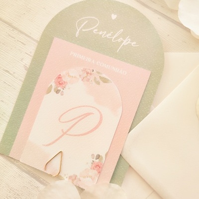 Convite delicado para primeira comunhão com design floral e texto, sobre mesa clara