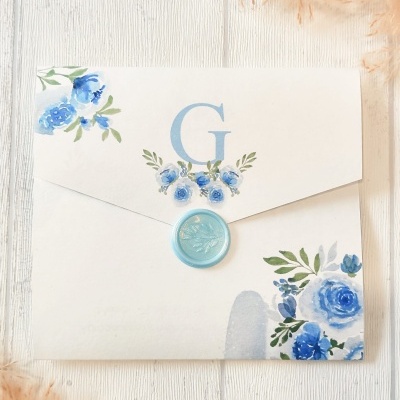 Envelope quadrado branco decorado com flores azuis e selo azul claro