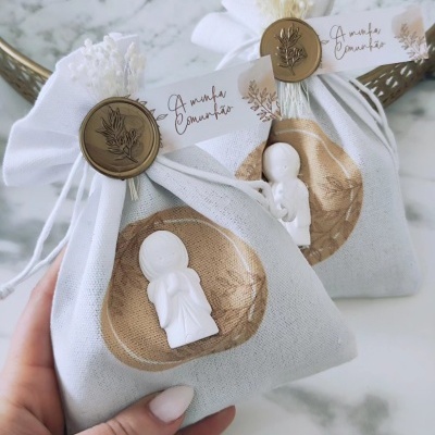 Duas bolsas pequenas de tecido decoradas com anjos brancos e etiquetas com 'A minha Comunhão'