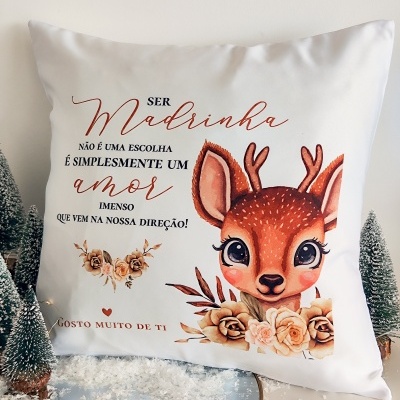 Almofada branca com desenho de cervo, flores e texto em português