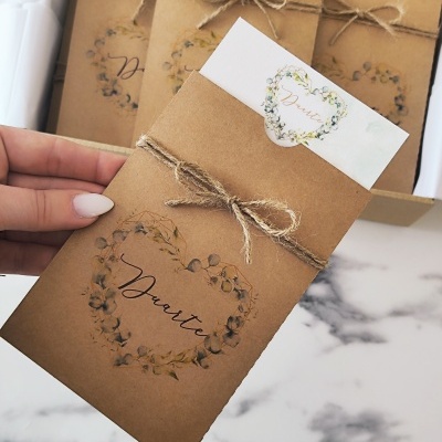 Envelope castanho com cordão e design floral, com cartão branco e nome Duarte