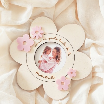 Moldura de madeira em forma de flor com texto em português e flores cor-de-rosa.