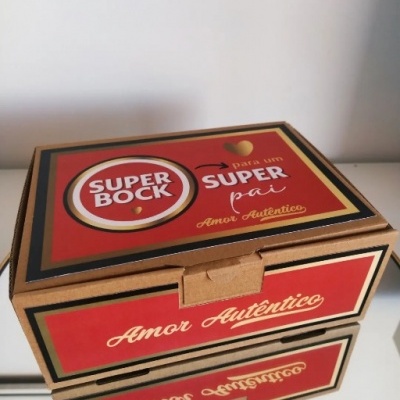Caixa de cartão vermelha com texto SUPER BOCK, SUPER pai, Amor Autêntico sobre superfície branca