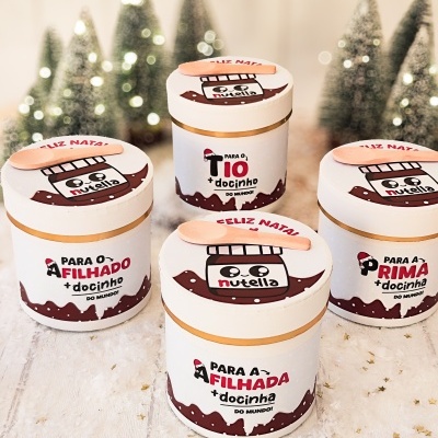 quatro frascos brancos decorados com pote de Nutella e texto para tio, filha, filho e prima com fundo de árvores de Natal