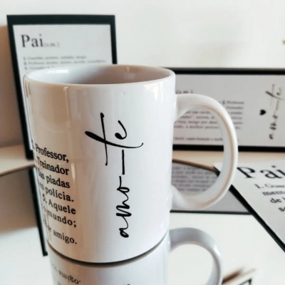 Caneca branca com texto em português ao lado de quadros com texto sobre 'Pai'