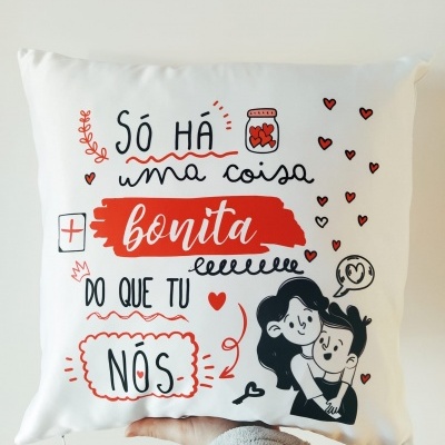 Almofada branca com texto e ilustração a preto e vermelho com casal e corações