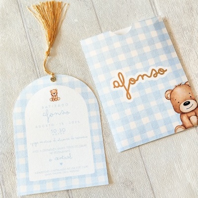 Convite de batizado com padrão azul claro e branco, ursinho e tassel dourado.