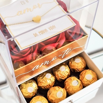 Caixa decorativa com bombons dourados, flores vermelhas, cartão e colar com coração