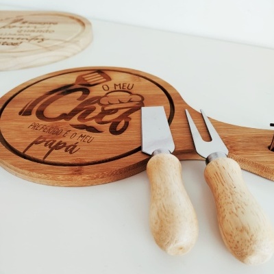 Tábua redonda de madeira com gravação e utensílios para queijo com cabos de madeira