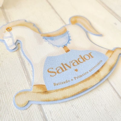Etiqueta cavalo de balanço azul e dourado com texto 'Salvador Batizado e Primeiro aniversário'