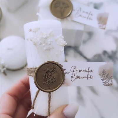 Vela branca decorativa com flores secas e selo de cera com mensagem 'A minha Comunhão'