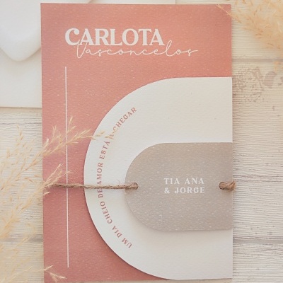 Convite texturizado rosa e bege com cordão e texto impresso, envelope branco ao fundo