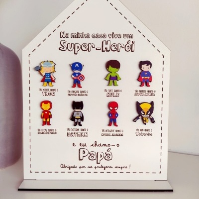 Placa decorativa de madeira em forma de casa com ímanes de super-heróis coloridos