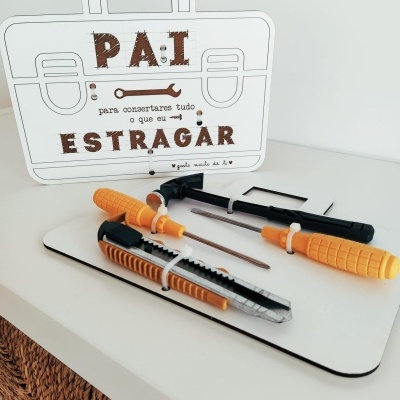 Conjunto de ferramentas com cabos laranja e preto e placa com texto em português sobre fundo branco.