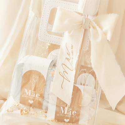 Saco transparente com alça branca e laço de tecido branco com mensagem para mãe.