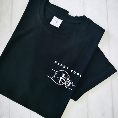 T-shirt preta com estampado branco 'DADDY COOL' e punhos a dar 'fist bump'