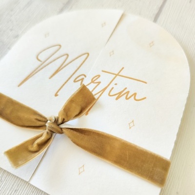 Convite branco com texto Martim em dourado e fita de veludo castanha