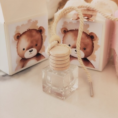 Frasco quadrado transparente com tampa de madeira e cordão, duas caixas com desenho de urso castanho