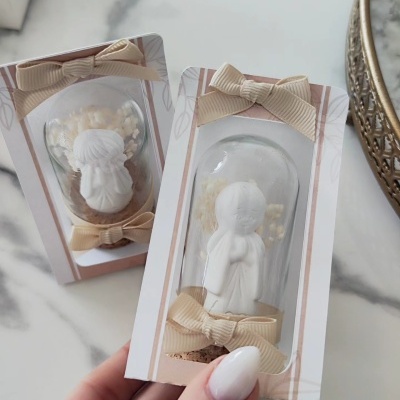 Pequenos anjos de resina branca em caixas transparentes com laços bege