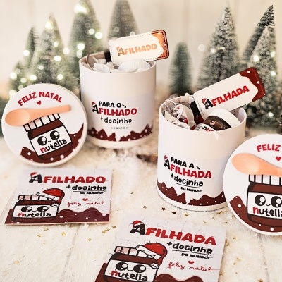 Produtos Nutella embrulhados para Natal com texto 'FELIZ NATAL' e 'PARA O(A) FILHADO(A) + docinho' e ilustração de pote de Nutella sorridente