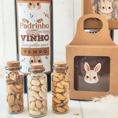 Garrafa de vinho com rótulo humorístico, frascos de vidro com amendoins e embalagens de cartão com figura de coelho