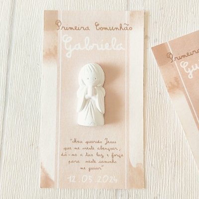 Cartão para Primeira Comunhão com figura branca de criança em oração e texto em castanho e branco sobre fundo bege