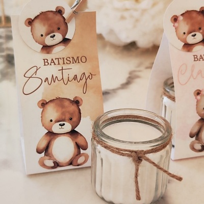 Vela branca em frasco de vidro com saco decorativo e texto BATISMO Santiago