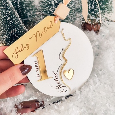 Ornamento natalício branco redondo com número 1 dourado e etiqueta 'Feliz Natal'
