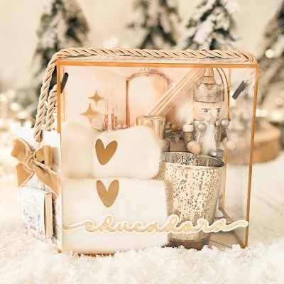 Conjunto de presente com toalhas, castiçal, soldado decorativo em caixa transparente com neve e árvores desfocadas ao fundo