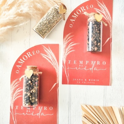 Cartões vermelhos com frascos de vidro e especiarias, texto em português e decoração natural