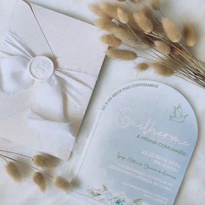 Convite de comunhão azul claro com envelope branco e flores secas.