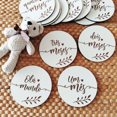 Placas redondas brancas com texto em caligrafia castanha e boneco de crochê sobre tapete trançado.