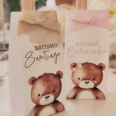 Caixas de lembranças para batismo com desenhos de ursinhos e laços em tons bege e rosa.